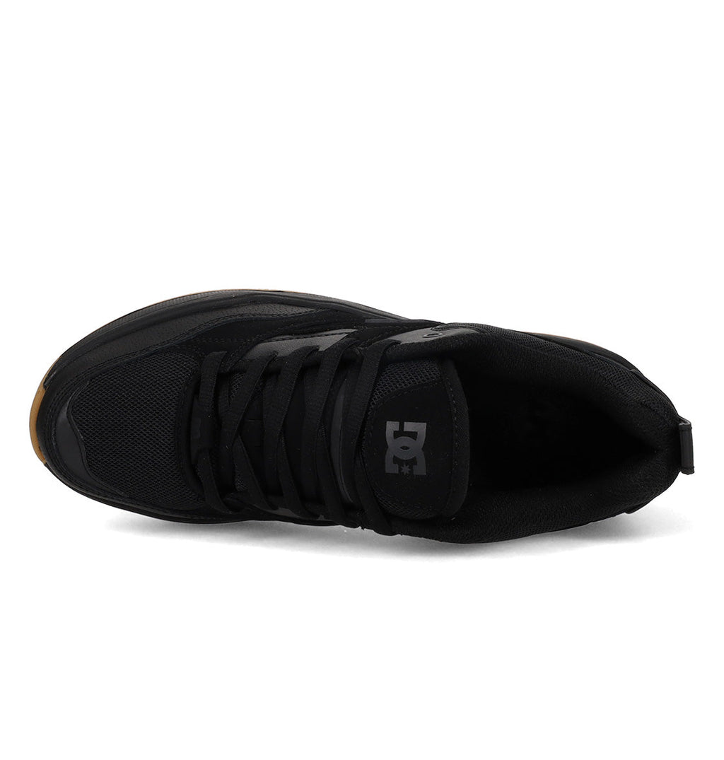 Top view of the Men’s Ascend Skate Shoes by DC Shoes—a black athletic sneaker with black laces and mesh accents. This low-profile shoe displays the DC Shoes logo on the tongue and combines classic sneaker styling with modern comfort. The sole edge features a subtle brown accent at the toe, adding a distinctive touch.