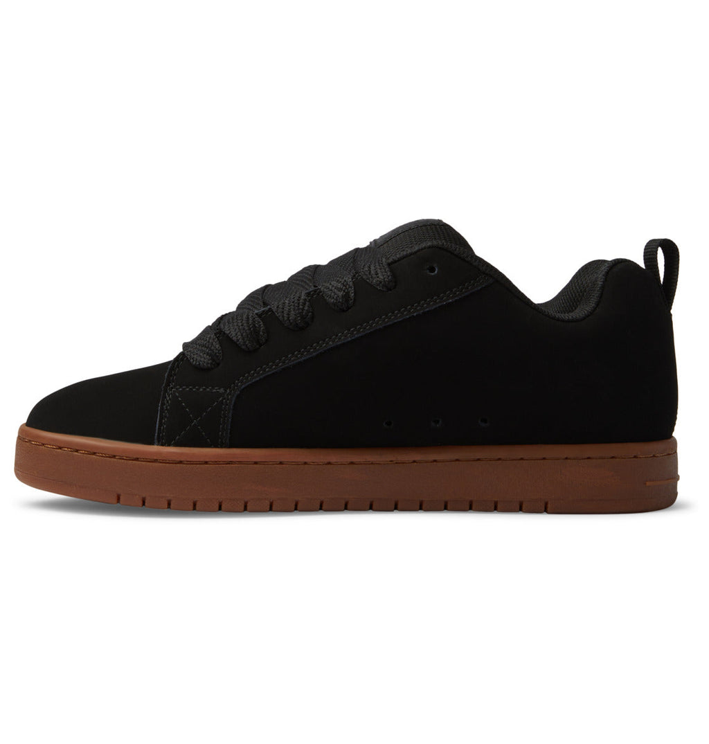 The DC Shoes Men’s Court Graffik Shoes are shown in a side profile view against a white background, featuring a black low-top design with a classic puffy silhouette, black laces, and a brown rubber sole. Subtle details like the signature DC logo emphasize their iconic Court Graffik style.