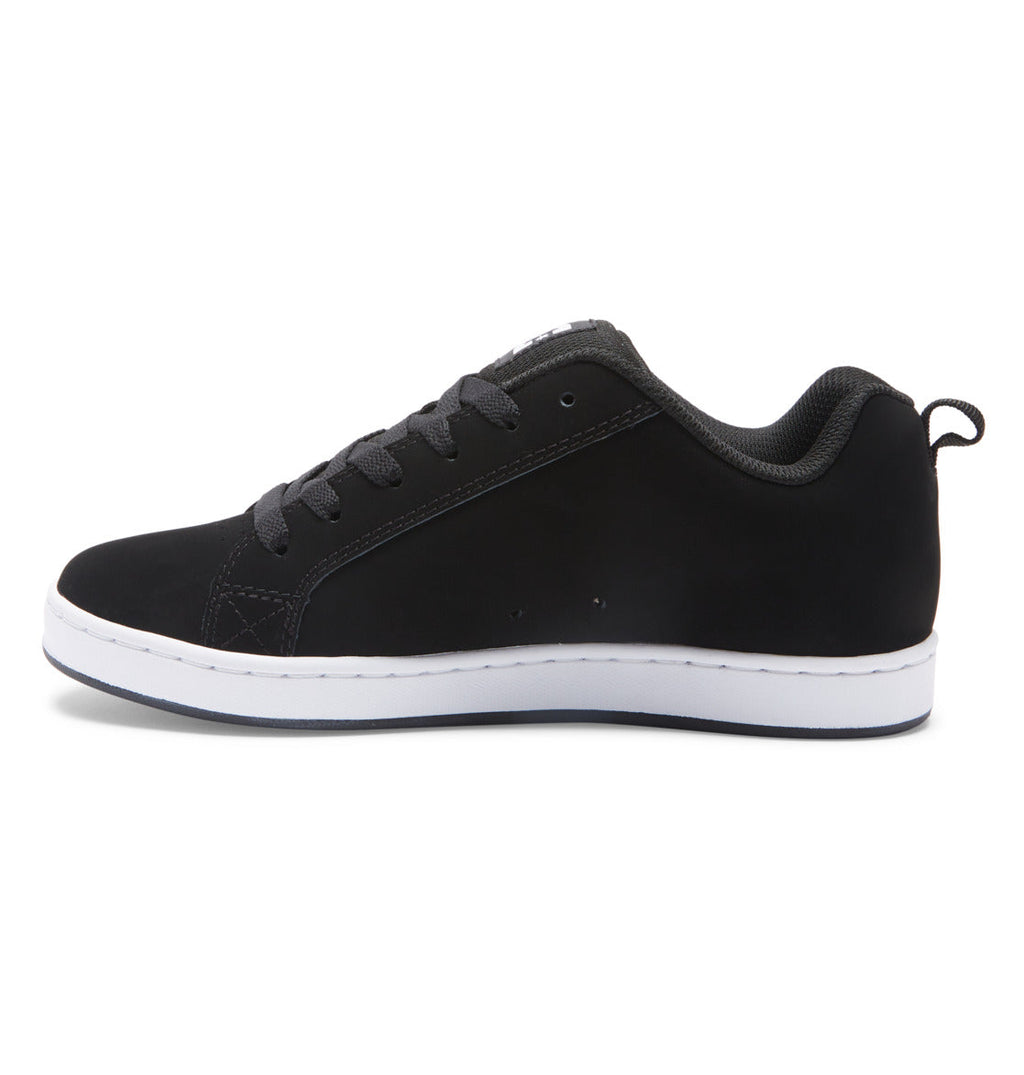 The Women’s Court Graffik Shoes by DC Shoes are shown in a side profile against a white background, featuring a black low-top design with matching laces and stitching, set atop a white sole—a classic look accented with subtle ’90s-inspired style.