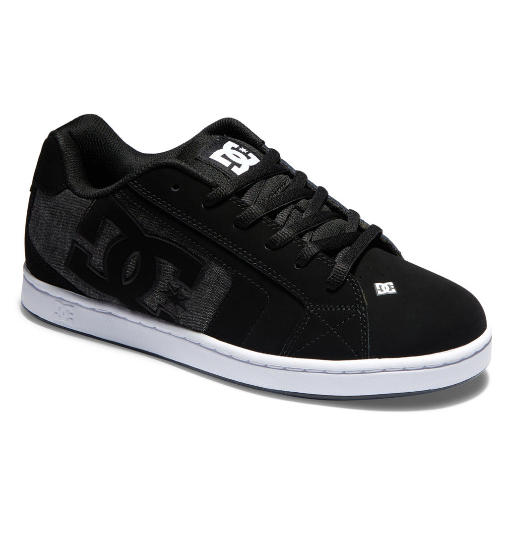 The Men’s Net Shoes by DC Shoes feature a black puffy design with a white sole, black laces, and a prominent DC logo on the side. Additional small white DC logos are found on the tongue and near the toe, while the outer sides showcase grey textured panels made from durable fabric.