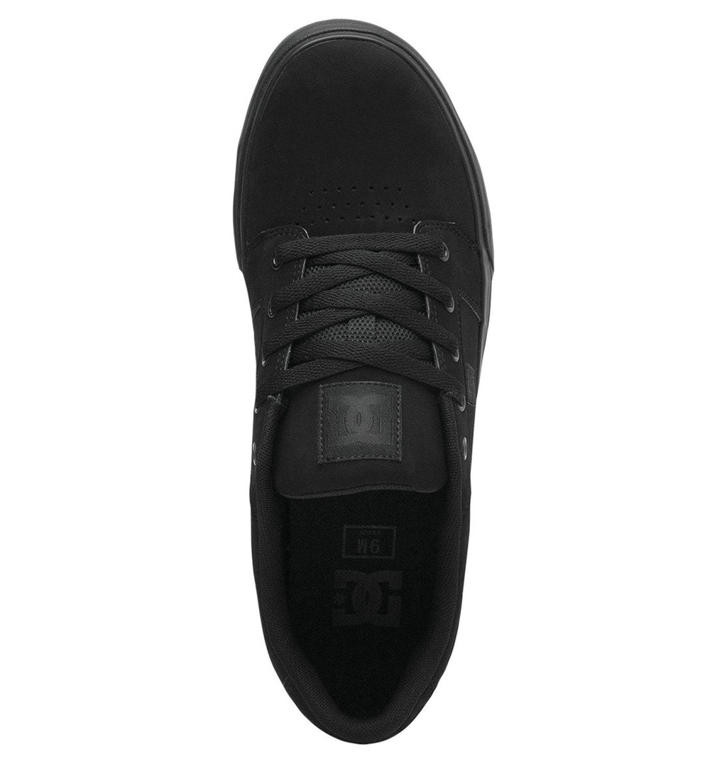 A top view of the DC Shoes Men’s Anvil Shoes in black, featuring black laces and a black tongue, is shown on a white background. The shoe displays subtle DC branding on the tongue and insole, delivering all-day comfort with its skate-inspired design.