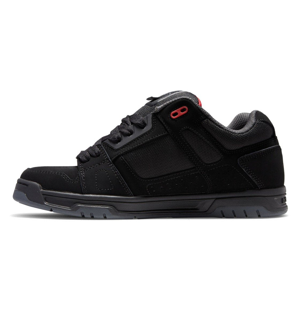 The Men’s Stag Shoes by DC Shoes feature a black athletic design with a low profile, durable cupsole, textured sole, breathable mesh panels, and a subtle red accent near the top lace eyelet. Set against a white background, these sneakers perfectly blend technical innovation and signature DC Shoes style.