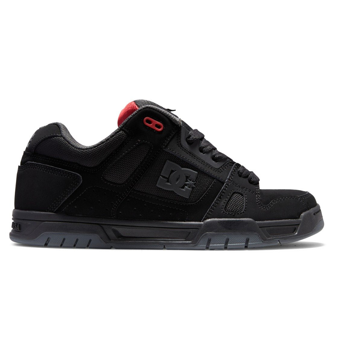 The DC Shoes Men’s Stag Shoes is a black skate shoe with a durable cupsole construction, technical design, thick sole, red accent near the ankle, and features the iconic DC Shoes logo on the side.