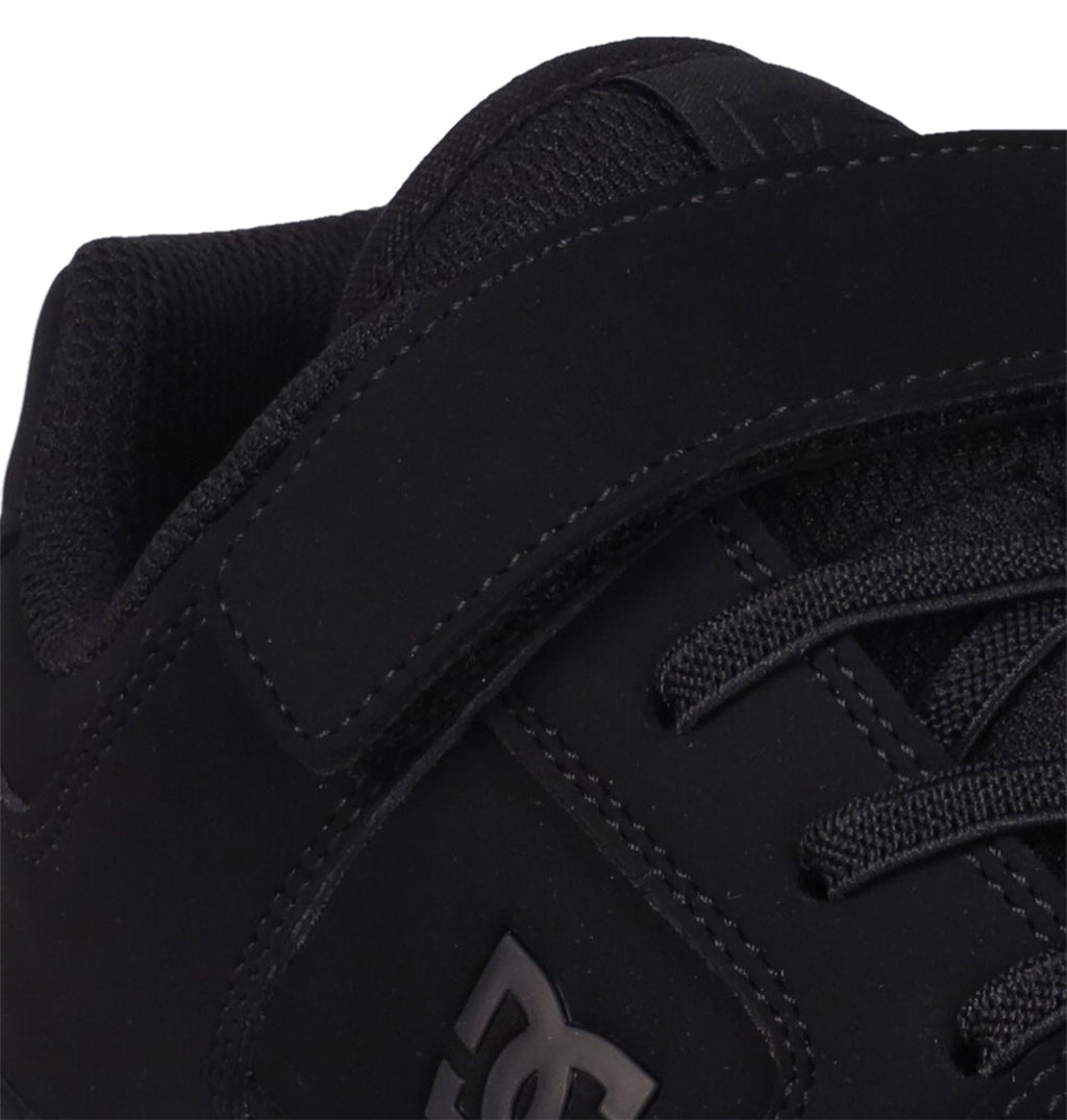 Close-up of a black Kids’ Manteca 4 V Shoe by DC Shoes, highlighting the durable suede or nubuck upper, visible stitching details, laces, and the signature stitched logo on the side—staying true to the classic Manteca skate shoe style.