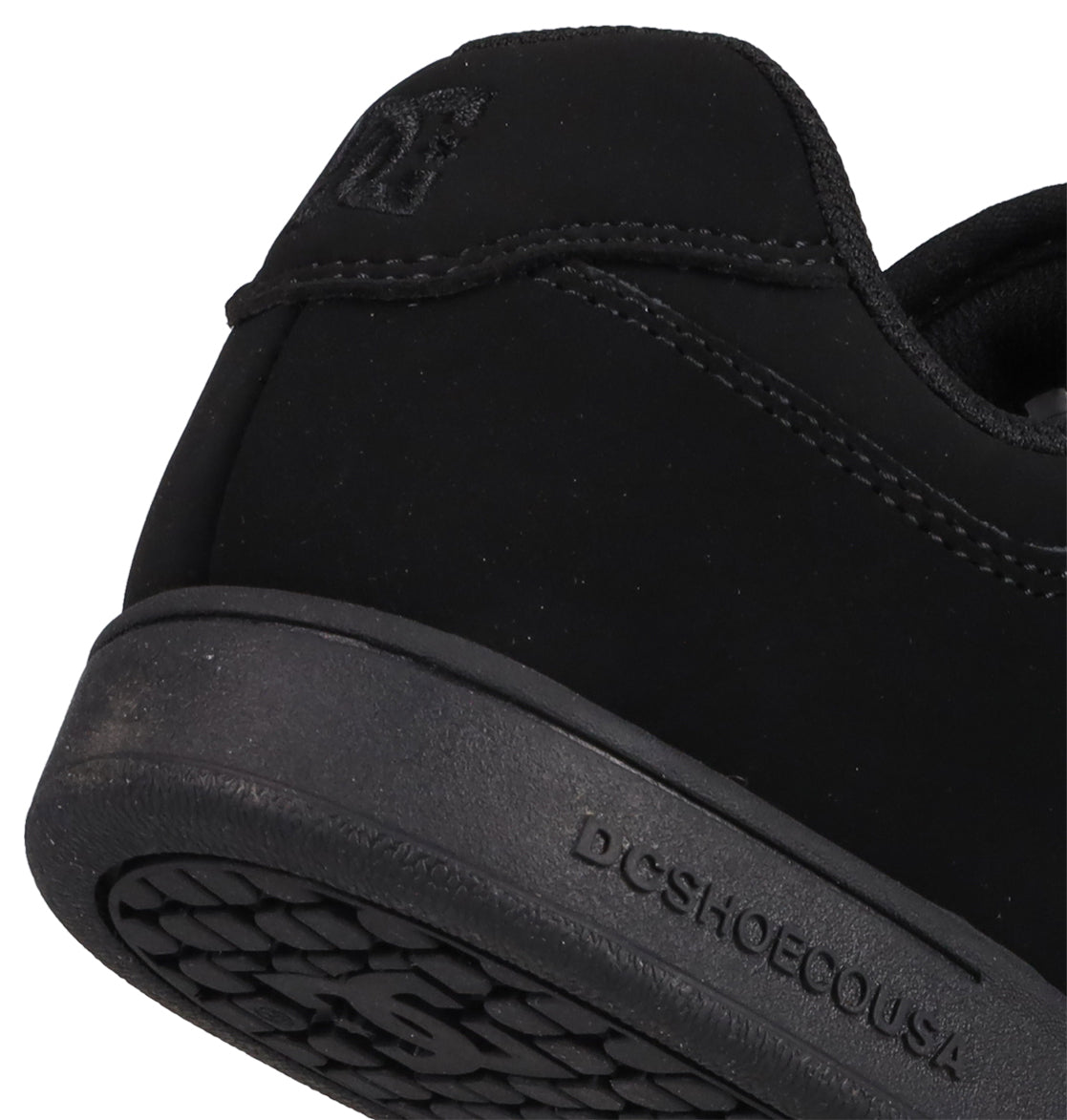 Close-up of the heel and sole of a black Kids’ Manteca 4 V Shoe from DC Shoes, with “DC SHOESCOUSA” embossed on the midsole. This sneaker, part of the Manteca skate shoes collection, showcases visible stitching, durable suede accents, and a textured rubber outsole.