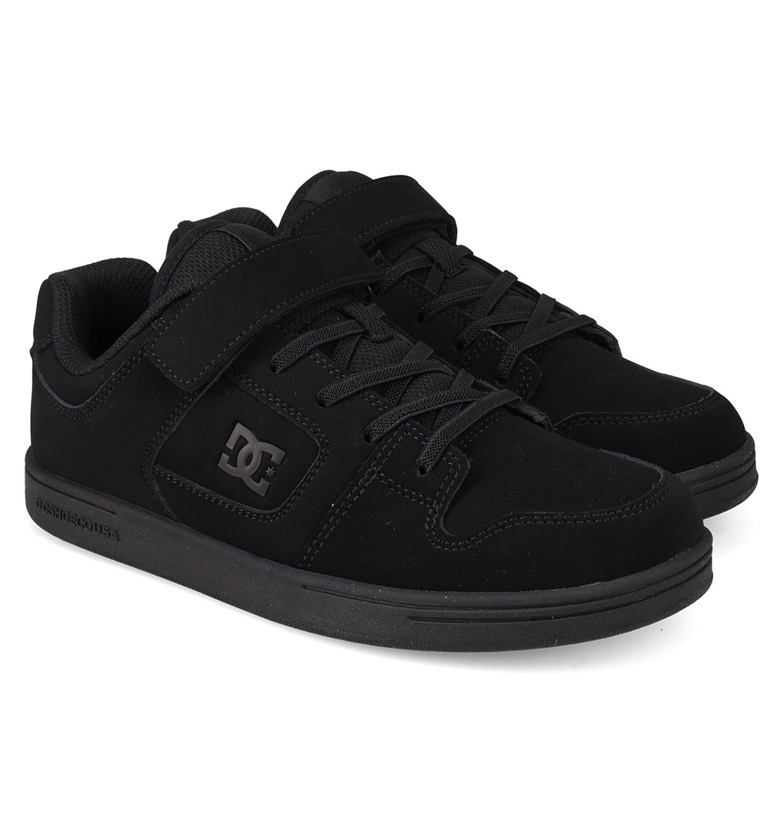 A pair of DC Shoes Kids’ Manteca 4 V Shoes in black, featuring laces and a Velcro strap for easy fastening, the signature DC logo on the side, and a thick rubber sole. Constructed from durable suede, these kid-friendly sneakers are ideal for active days on the go.