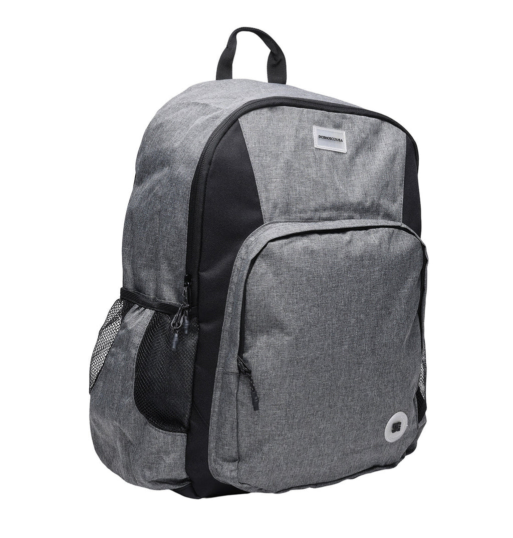 The DC Shoes Locker Backpack, shown against a white background, is gray with black accents and features a front zippered pocket, mesh side pockets, a small top handle, adjustable shoulder straps, and a padded laptop sleeve.