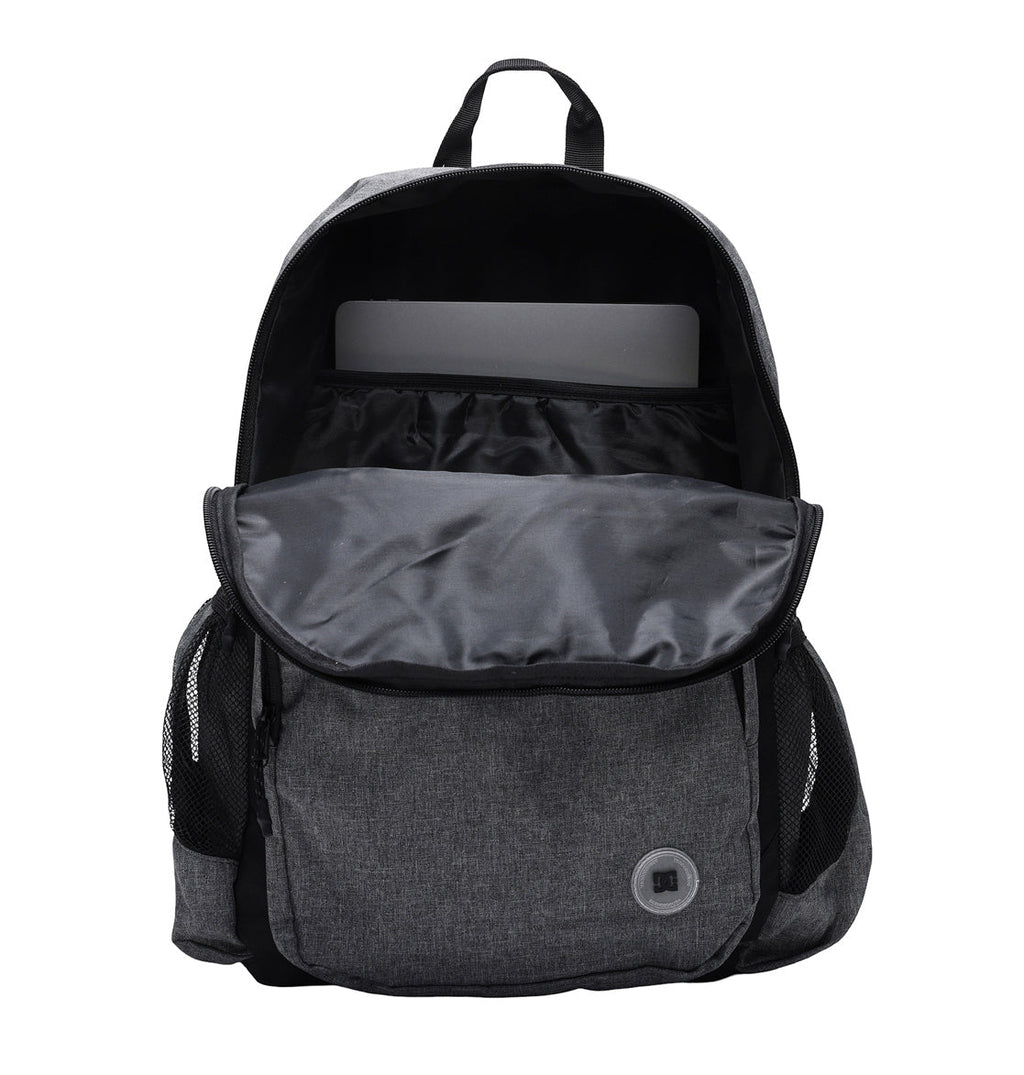 The DC Shoes Locker Backpack is shown in gray with its main compartment open, displaying a laptop inside a padded sleeve. The backpack features side mesh pockets, a front pocket, and is set against a plain white background.