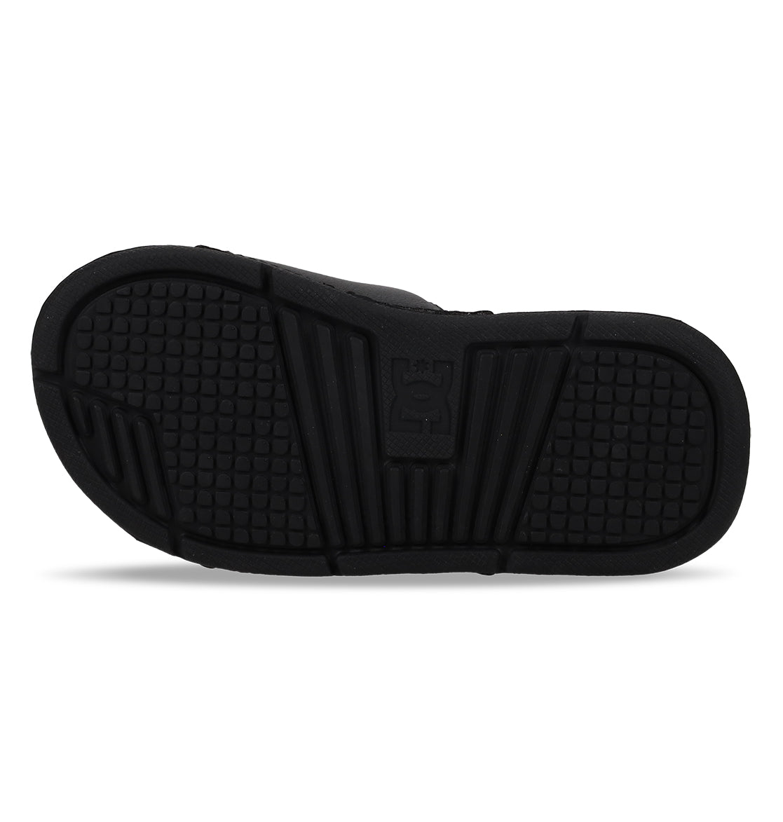 The image shows the black rubber sole of DC Shoes Kids' Bolsa Slides, featuring square-patterned treads and grooves for grip, plus a raised logo in the center—ideal for comfy kids slide sandals.
