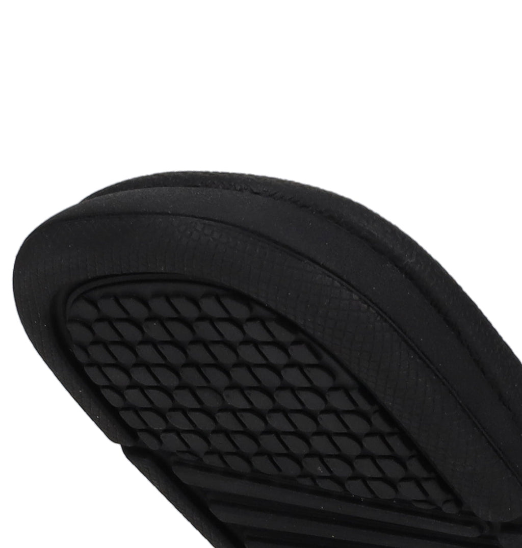 Close-up of the sole on DC Shoes Kids' Bolsa Slides, featuring a black diamond-patterned grip—offering secure comfort and standout style.