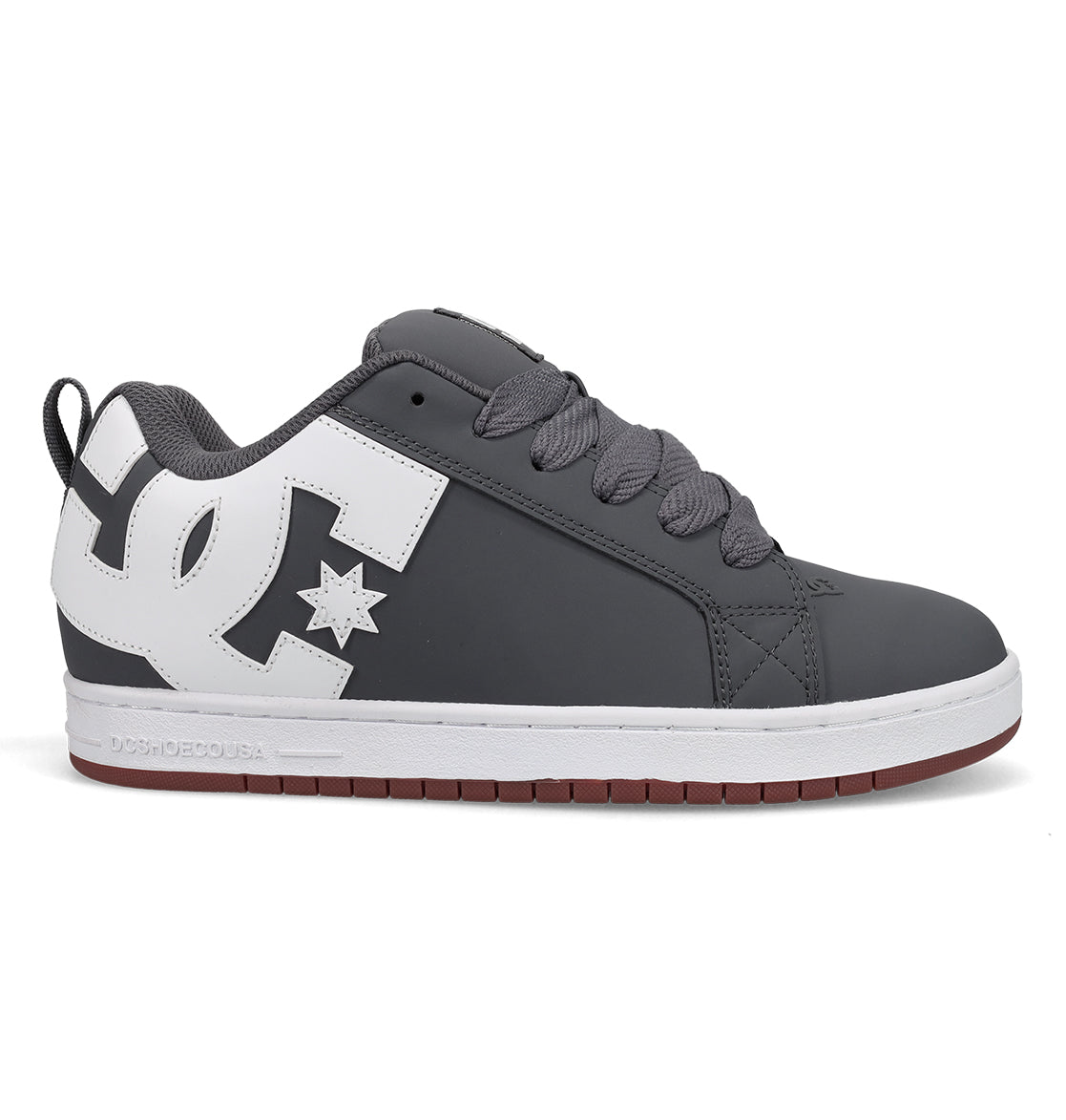 A gray and white men’s skate shoe from DC Shoes’ Court Graffik line, featuring a prominent white DC logo on the side, gray laces, and a white sole with a red-brown bottom.