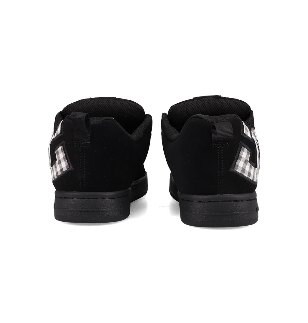 A pair of Men's Court Graffik Shoes by DC Shoes, featuring a classic puffy silhouette and black-and-white checkered side details, shown from the back on a white background.