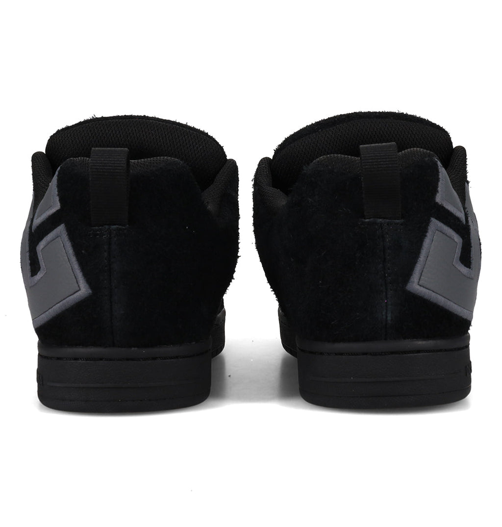Back view of the DC Shoes Men’s Court Graffik Special Edition Shoes in black, featuring gray geometric designs on the heels, a two-tone sole, puffy silhouette, and pull tabs at the top of the heel.