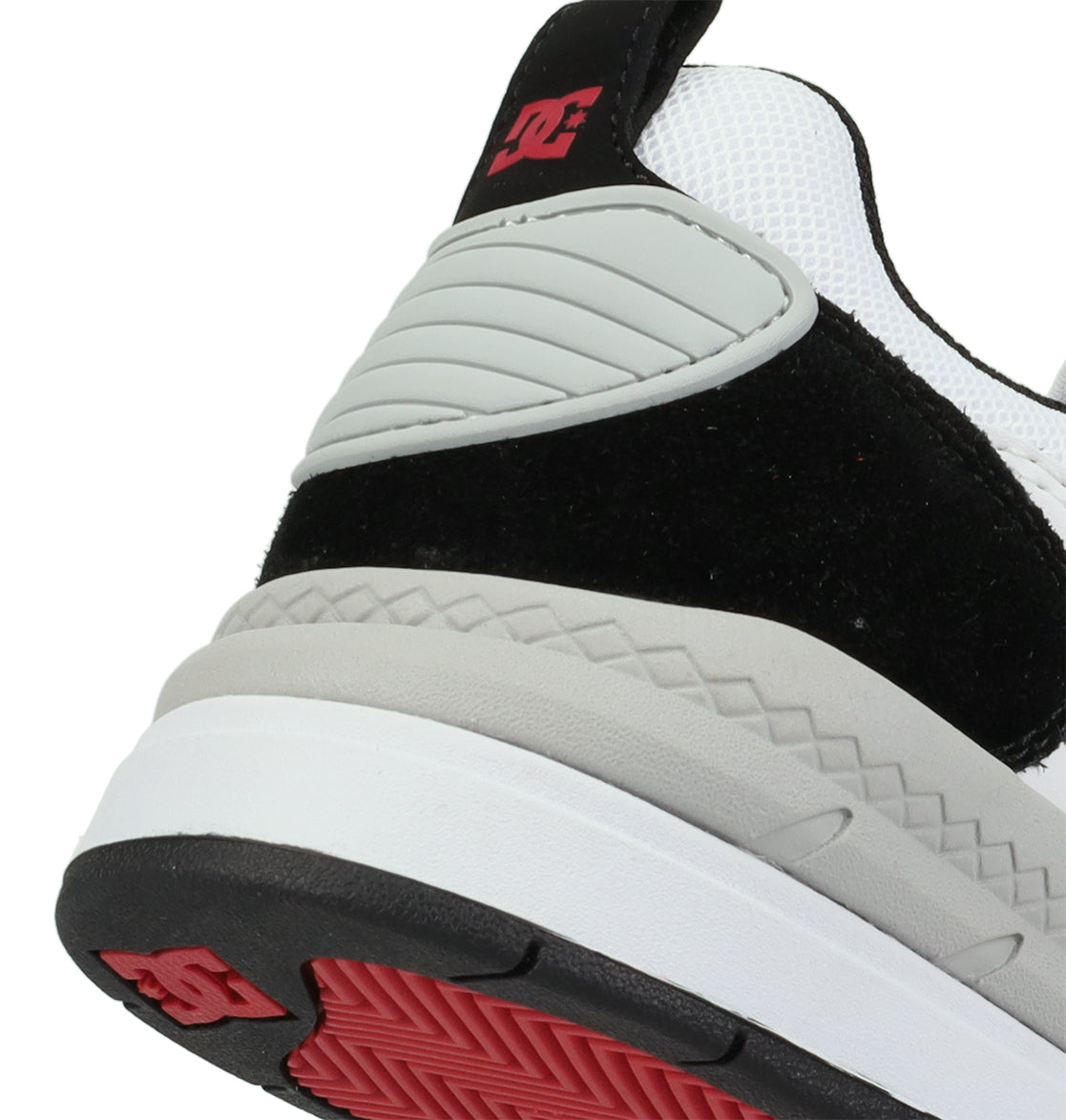 Close-up of the heel of the DC Shoes Men’s Ascend Skate Shoes, featuring black, white, and grey panels with red accents and a red DC logo on the back tab and outsole. Inspired by Josh Kalis and rooted in DC DNA, this design delivers modern comfort with a textured pattern on the sole.