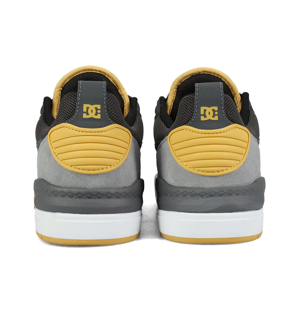 A pair of DC Shoes Men’s Ascend Skate Shoes viewed from the back, featuring black, grey, and yellow colors with yellow logo and heel accents on a white and grey sole, perfectly blending DC heritage with modern comfort for everyday wear.