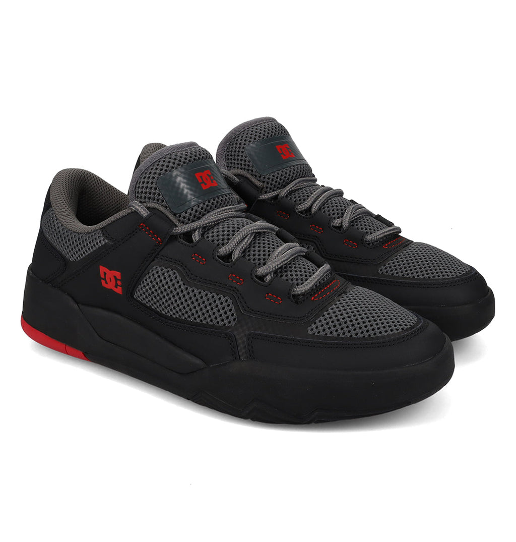 The DC Shoes Men’s Metric Shoes feature a black and gray colorway accented with striking red details and breathable mesh panels. Showcasing the iconic DC logo on both the side and tongue, these shoes come with gray laces and a thick, textured sole that blends comfort with style.