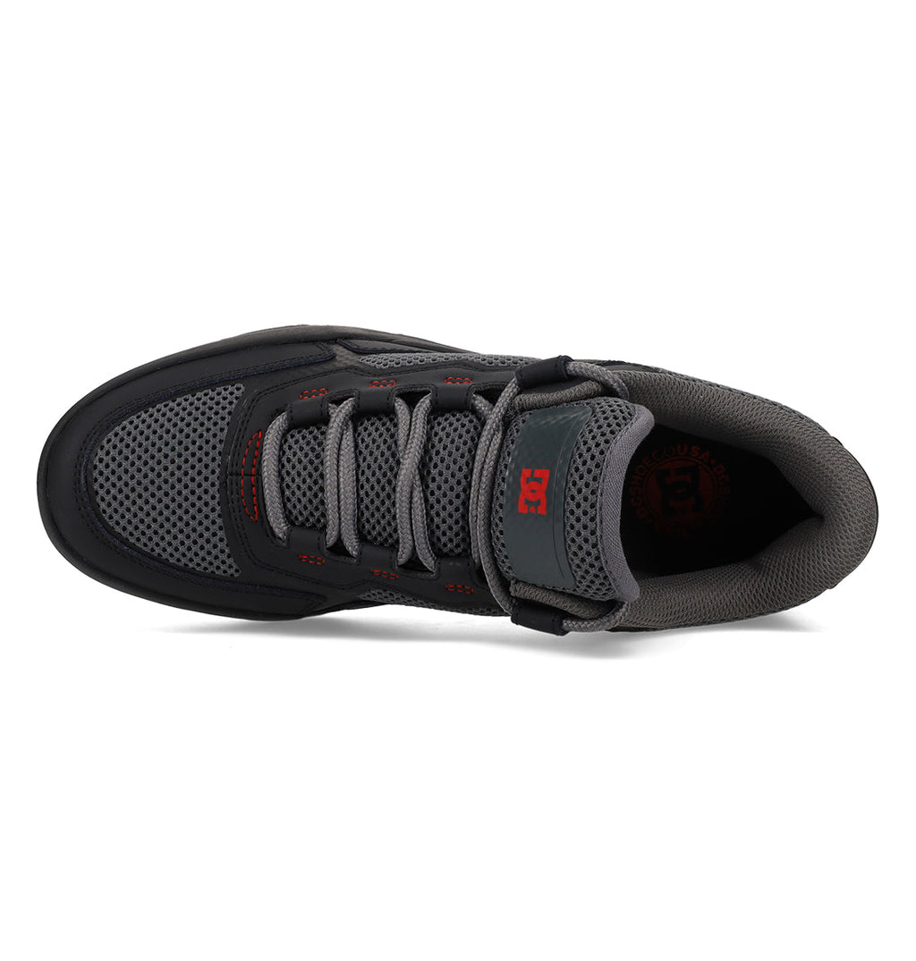 A top view of the DC Shoes Men’s Metric Shoes in dark gray and black showcases mesh and suede details, gray laces, a Velcro strap, and striking red logo accents on the tongue and side. These stylish shoes blend comfort with bold design elements for a standout look in black, grey, and red.
