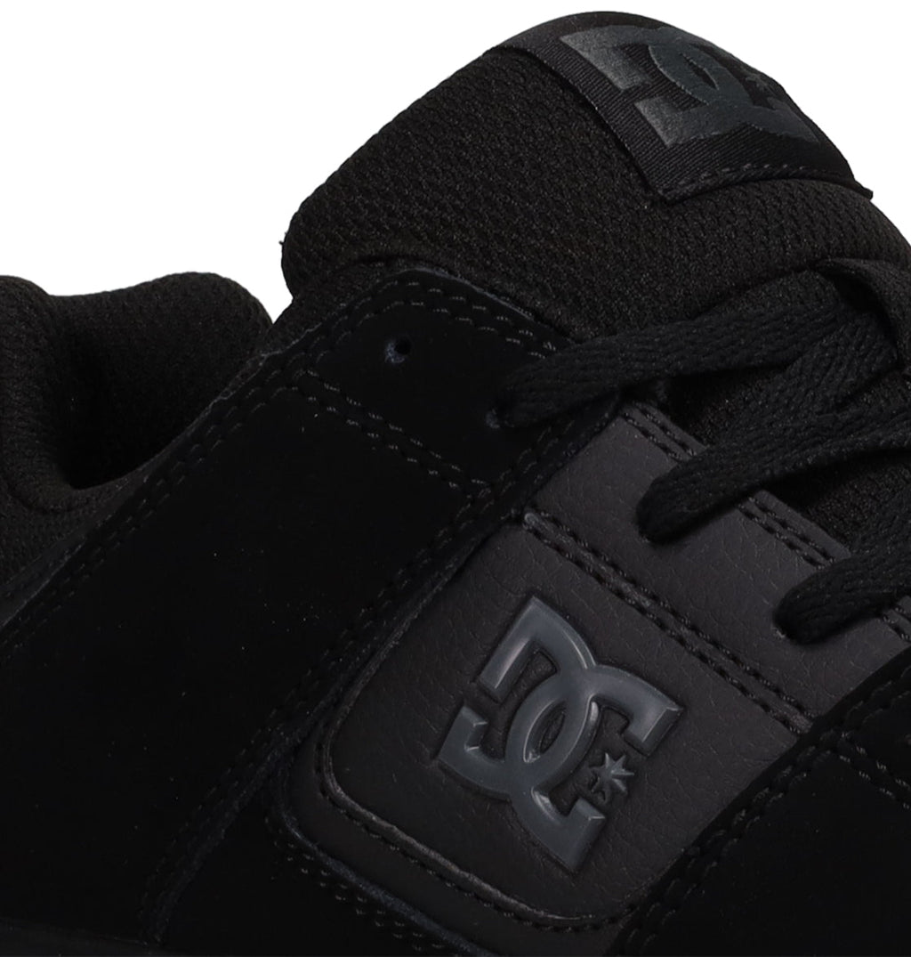 Close-up of the Men’s DC Cure Shoes in black by DC Shoes, highlighting the side logo, laces, and part of the tongue with the brand emblem. Crafted with a durable leather suede upper, these versatile shoes are ideal for everyday wear.