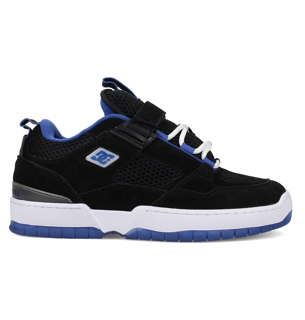 Introducing the Men’s JS-1 Shanahan Pro Skate Shoes by DC Shoes—a black and blue skate shoe with a white sole featuring the signature DC Pill Pattern Outsole, mesh and suede upper accents, the iconic DC logo on the side, blue inner lining, white laces, a foam padded collar for enhanced comfort, and a strap across the tongue.