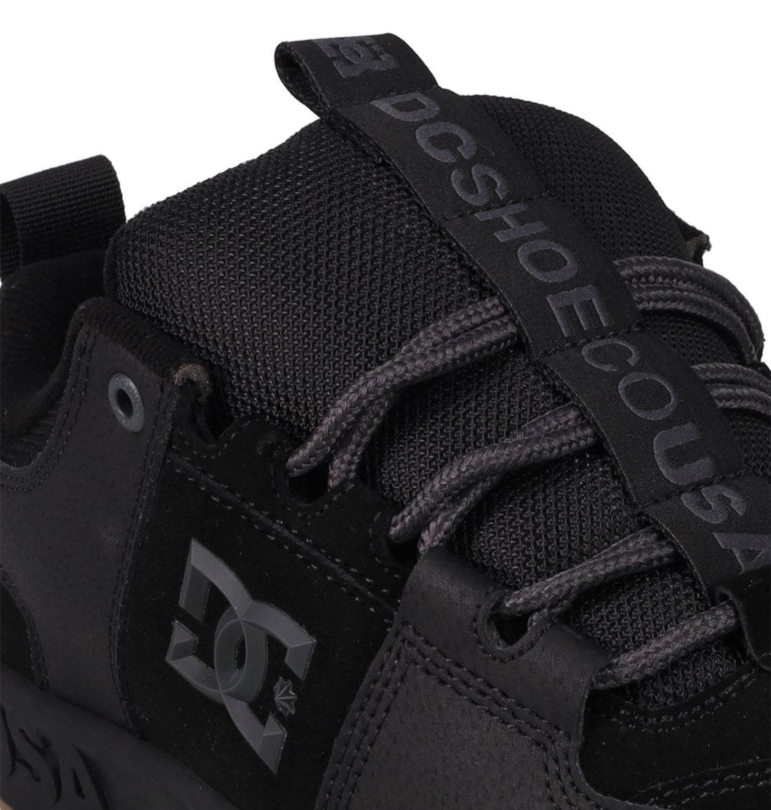 Close-up of the Men's Lynx OG Shoes by DC Shoes, featuring black and gray laces, a tongue strap with DCSHOECOUSA branding, and classic logo details—ideal for skateboarding.