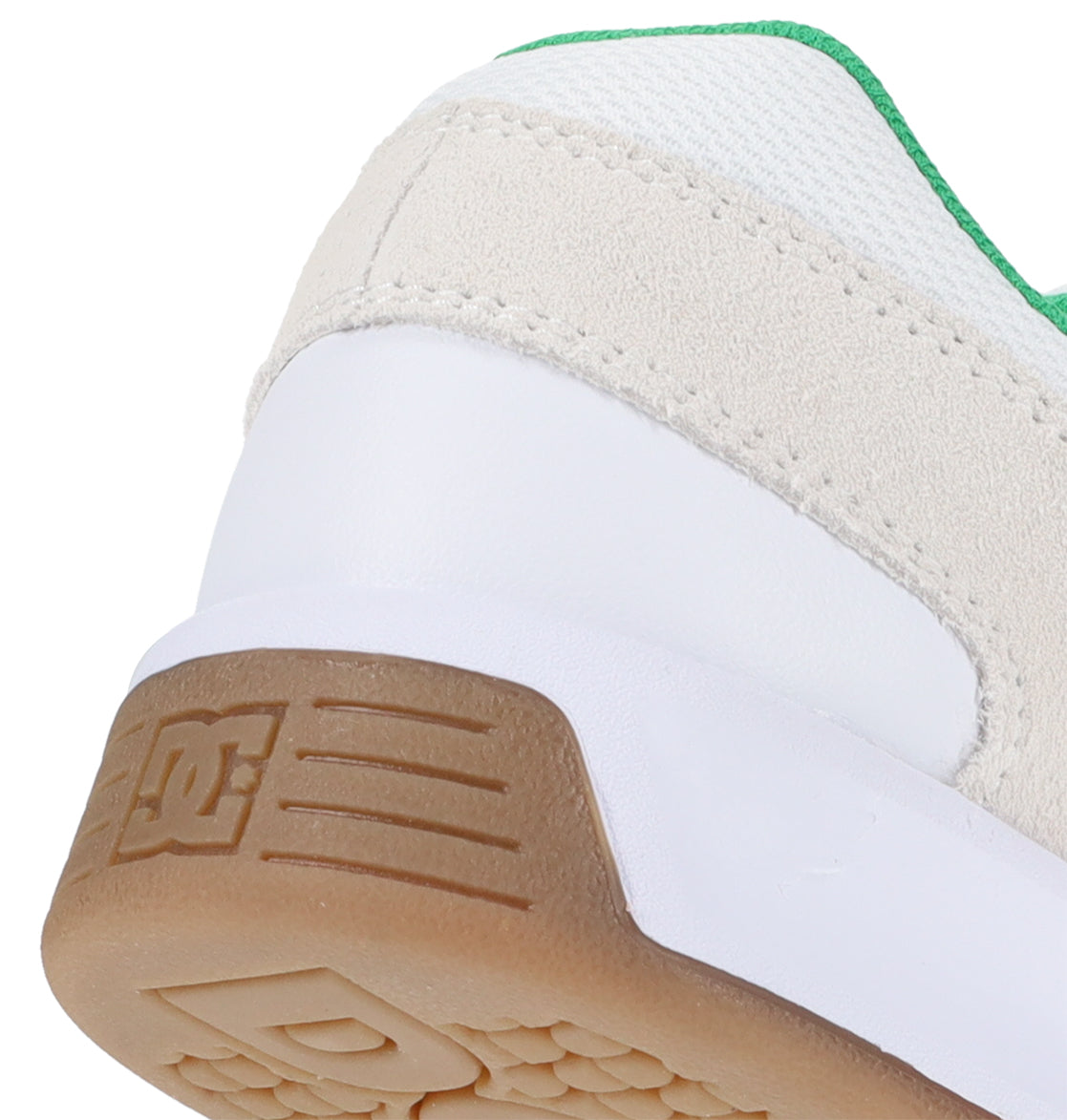 Close-up of the heel of a white and beige DC Shoes Men’s Lynx Shoe with a gum sole and green trim, featuring the embossed DC Shoes logo on the sole.