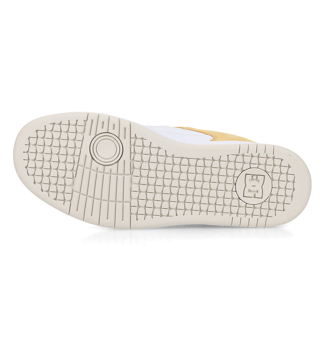The image displays the sole of a Men’s Manteca 4 Shoe by DC Shoes, featuring a white base with a grid-like tread pattern and a circular logo containing the letter “B” near the heel—highlighting the performance-driven design that defines DC Shoes.