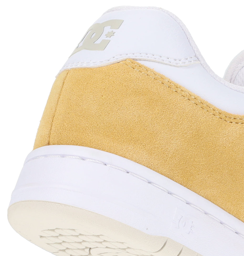 Detailed view of the back and side of the Men’s Manteca 4 Shoes by DC Shoes, highlighting a white upper heel, yellow suede side panel, and white outsole—all exemplifying the performance-driven design that defines this iconic sneaker.