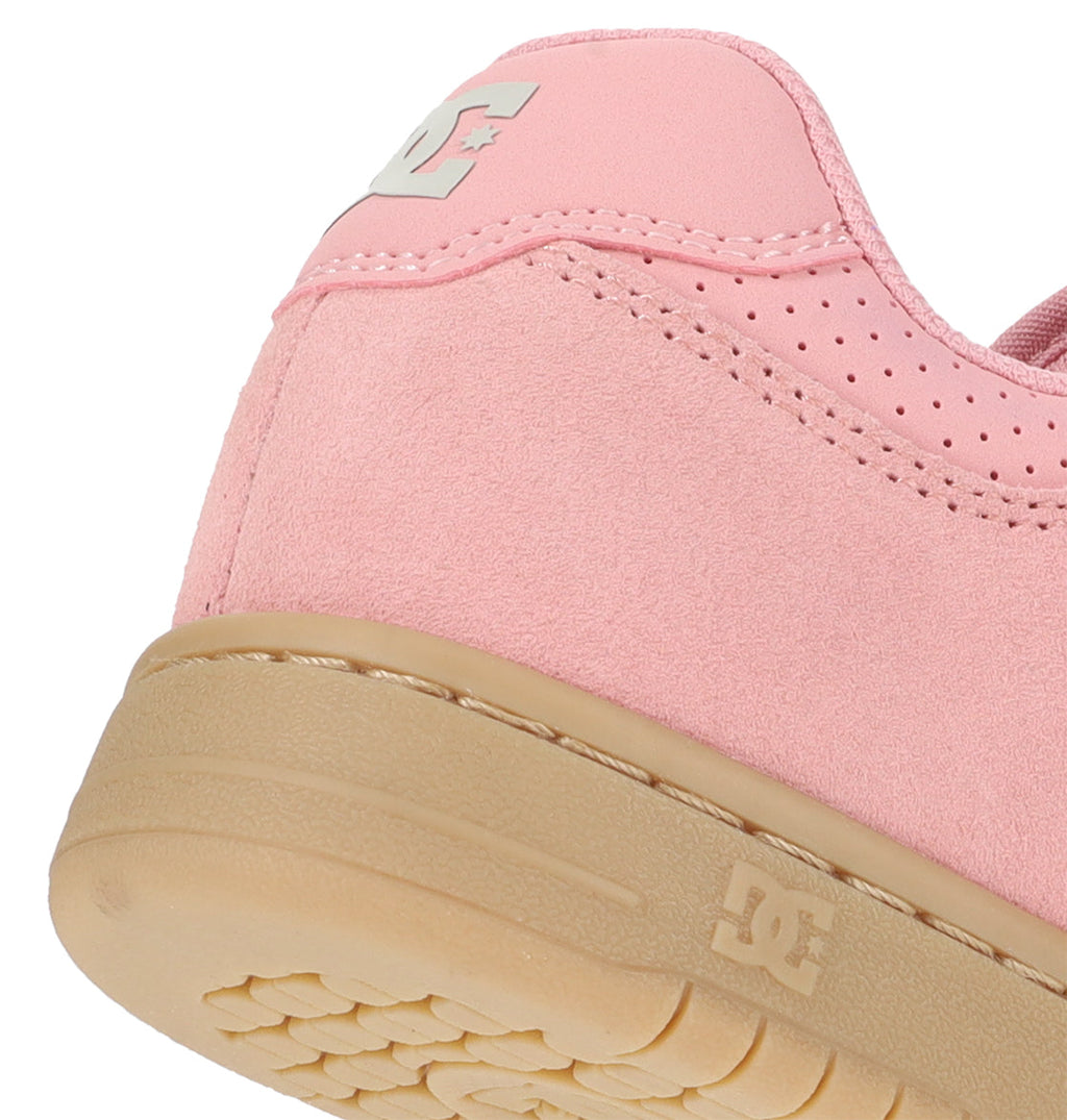 Close-up of the heel of the Women’s Manteca 4 Shoes by DC Shoes, featuring pink suede, a tan rubber sole, and the DC Shoes logo in white on the side and sole to highlight its classic style.