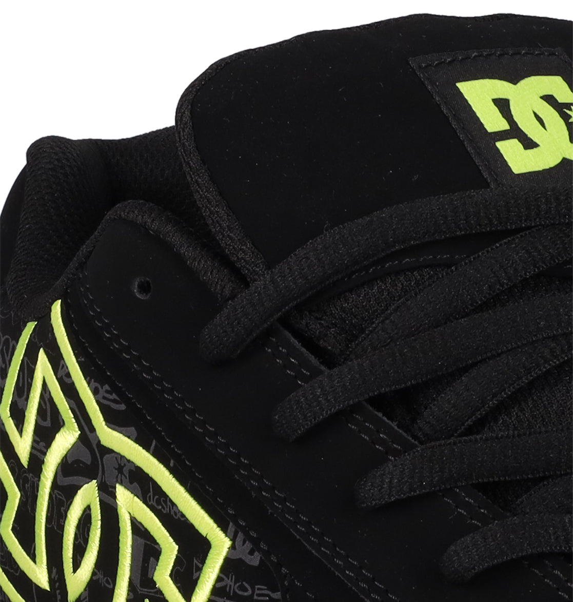 Close-up of Men's Net Shoes by DC Shoes, featuring a black design with neon yellow DC branding on the side and tongue, black laces, padded collar, and durable fabric construction.