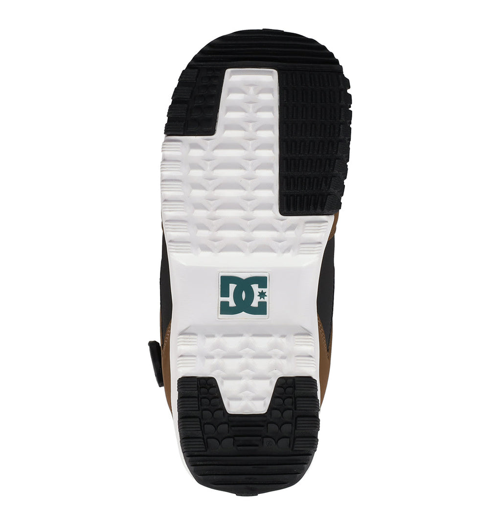 Sole detail of the DC Shoes Men’s Phase Boa Pro Snowboard Boots, showcasing a black and white tread pattern with the green DC Shoes logo at the center. The sole design, inspired by men’s snowboard boots, features diverse textures to enhance grip and support.