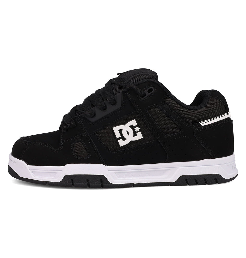 The DC Shoes Men's Stag features a black low-top design with black laces, subtle mesh and suede details, white sole, cupsole construction, and a white DC logo on the side—shown from the left.