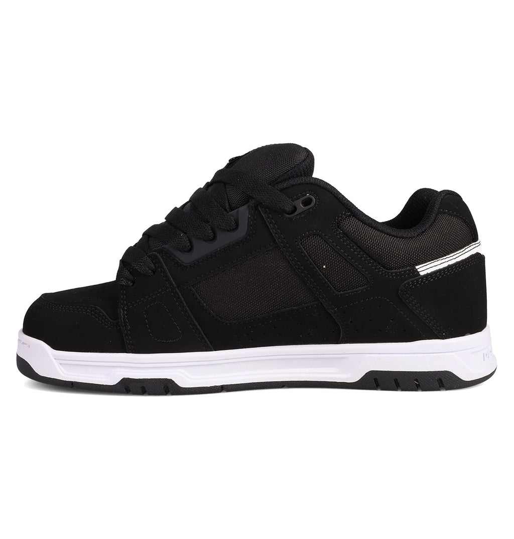 The DC Shoes Men's Stag Shoes are black athletic sneakers with mesh and suede panels, black laces, a thick white cupsole, padded collar, and subtle stitching details inspired by skate culture.
