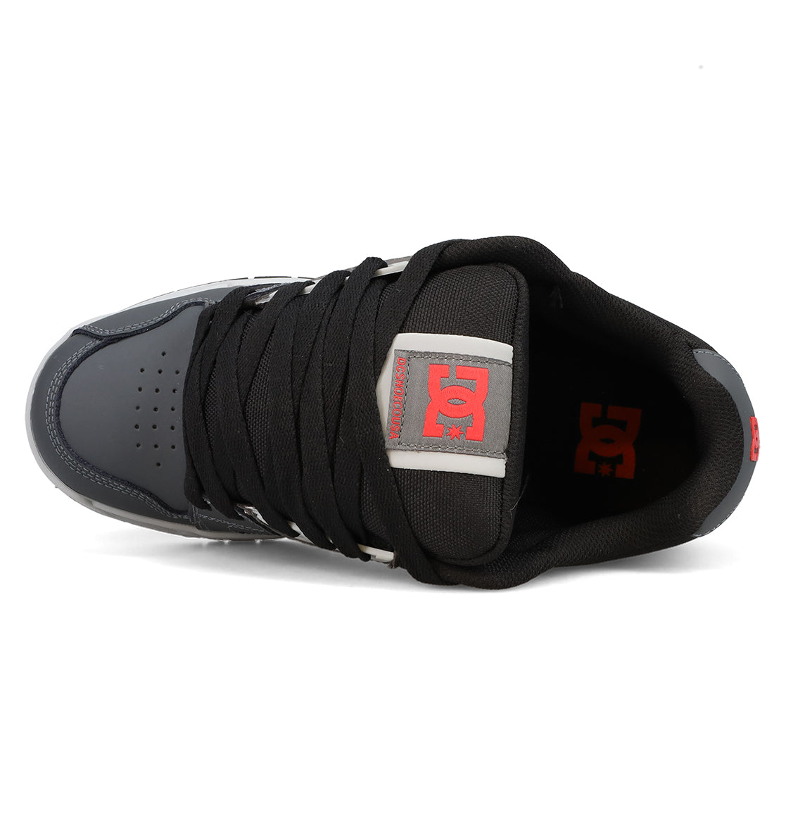 Top view of the Men’s Stag Shoes by DC Shoes in black and gray, showcasing thick black laces, a red DC logo on the tongue, and durable cupsole construction for added support—ideal for embracing authentic skate culture.