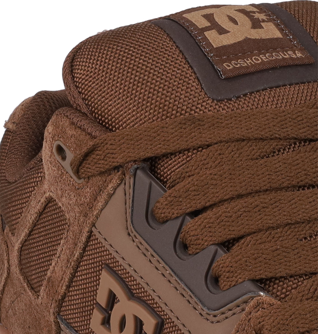 Close-up of the Men's Stag Shoes by DC Shoes, showcasing cupsole construction, textured fabric, suede accents, laces, and prominent DC Shoes logos on the tongue and side.