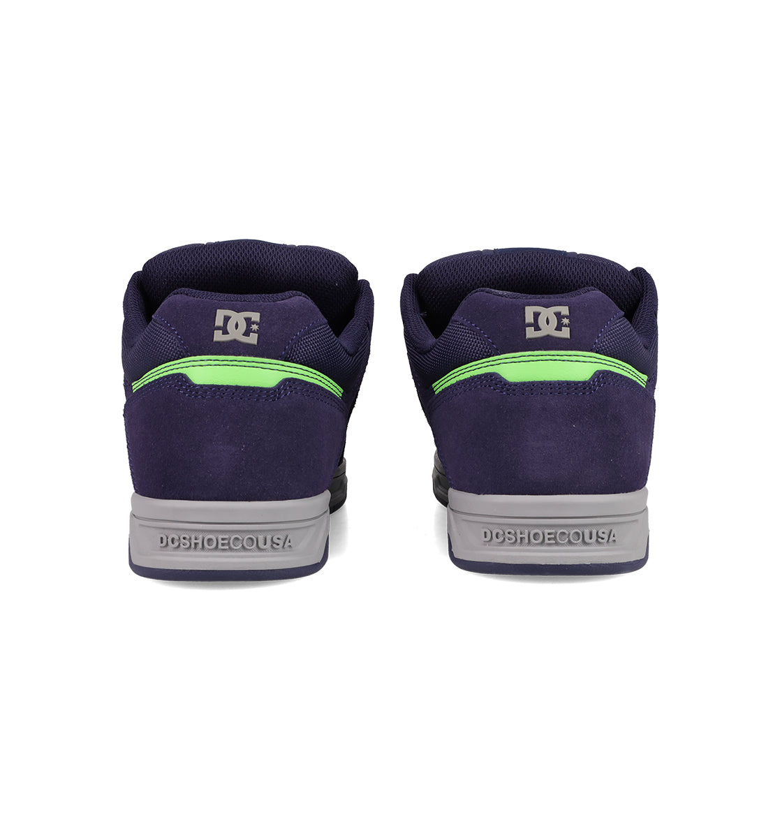 Men's Stag Shoes by DC Shoes in navy blue, shown from the back, have gray cupsoles, neon green details, and DC logos on heel and collar—ideal for skate culture fans.