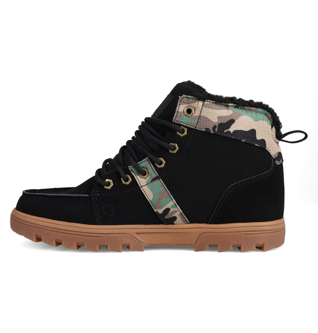 The Men's Woodland Winter Boots by DC Shoes are high-top sneakers inspired by Woodland Boots, with a black suede body, brown rubber sole, black laces, and camo pattern accents at the ankle and lace area—shown from the side.
