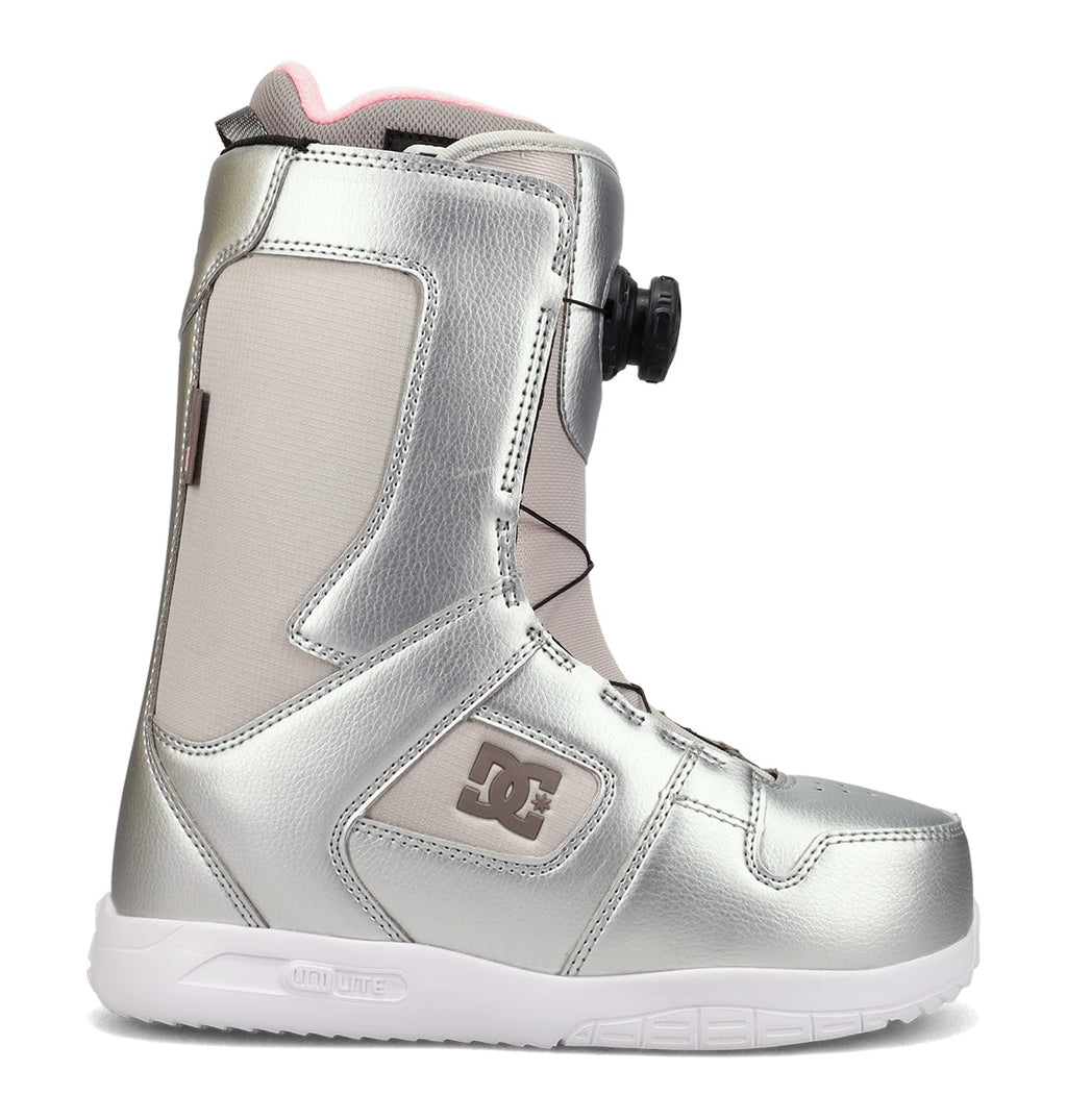 The DC Shoes Women’s Phase BOA® Snowboard Boots feature a silver metallic design with gray panels, a pink collar lining, the BOA® Fit System for secure lacing, a white UniLite sole, and IMPACT-ALG insoles for superior comfort and support.