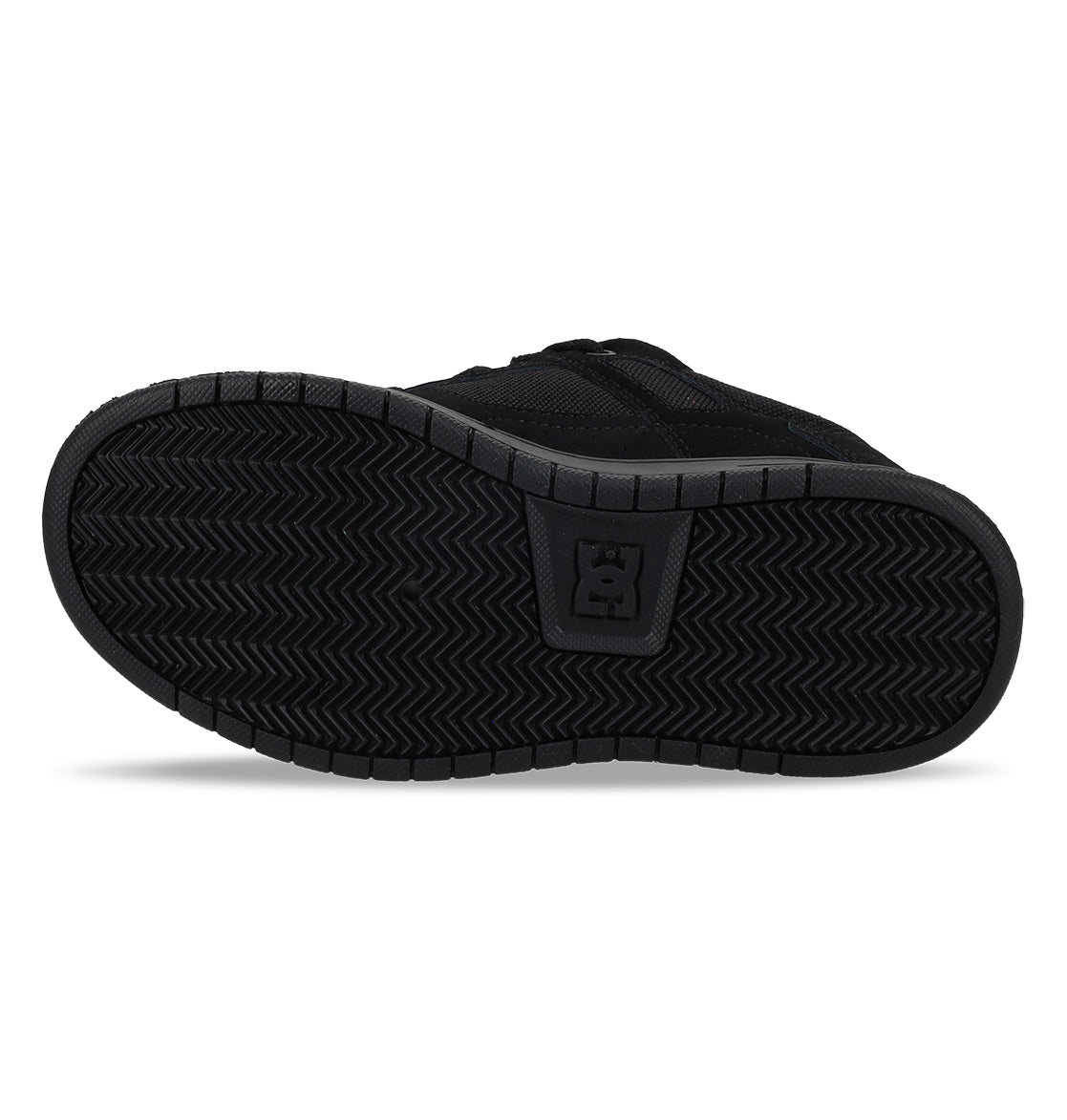 The image shows the black rubber sole of the Kids’ Stag Shoes by DC Shoes, featuring a herringbone tread pattern and a raised DC Shoes logo in the center, highlighting its durable cupsole construction.