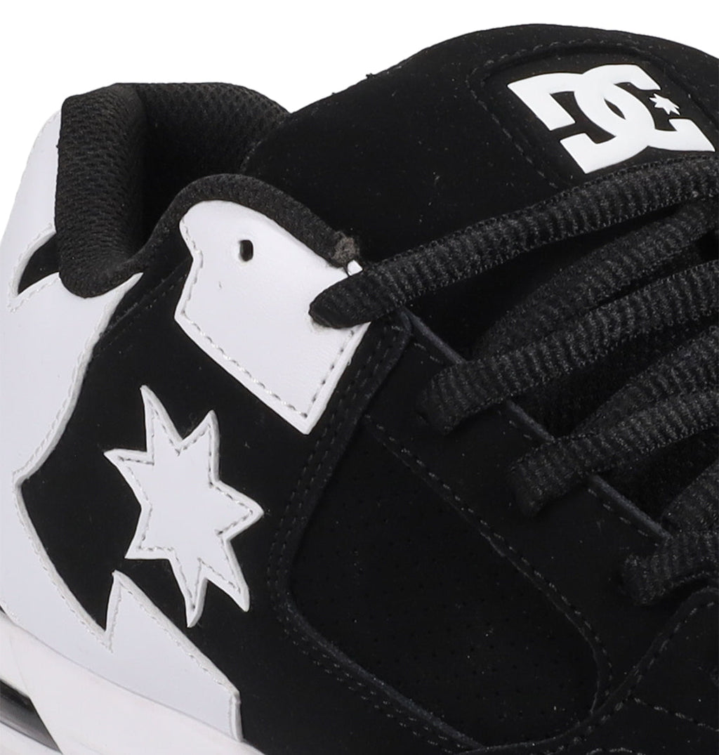 Close-up of the Men's Command Shoes by DC Shoes in black and white, showcasing the iconic logo on the tongue, black laces, and a star motif—combining classic DC style with modern sneaker features.