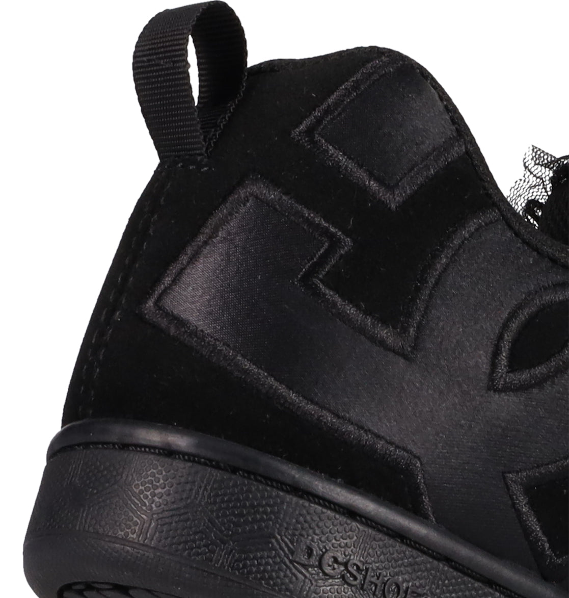 Close-up of the heel and side of DC Shoes Women's Court Graffik SD, featuring a black suede upper, textured sole, fabric pull tab, and bold shiny stitched logo—an on-trend puffy silhouette perfect for standout style.