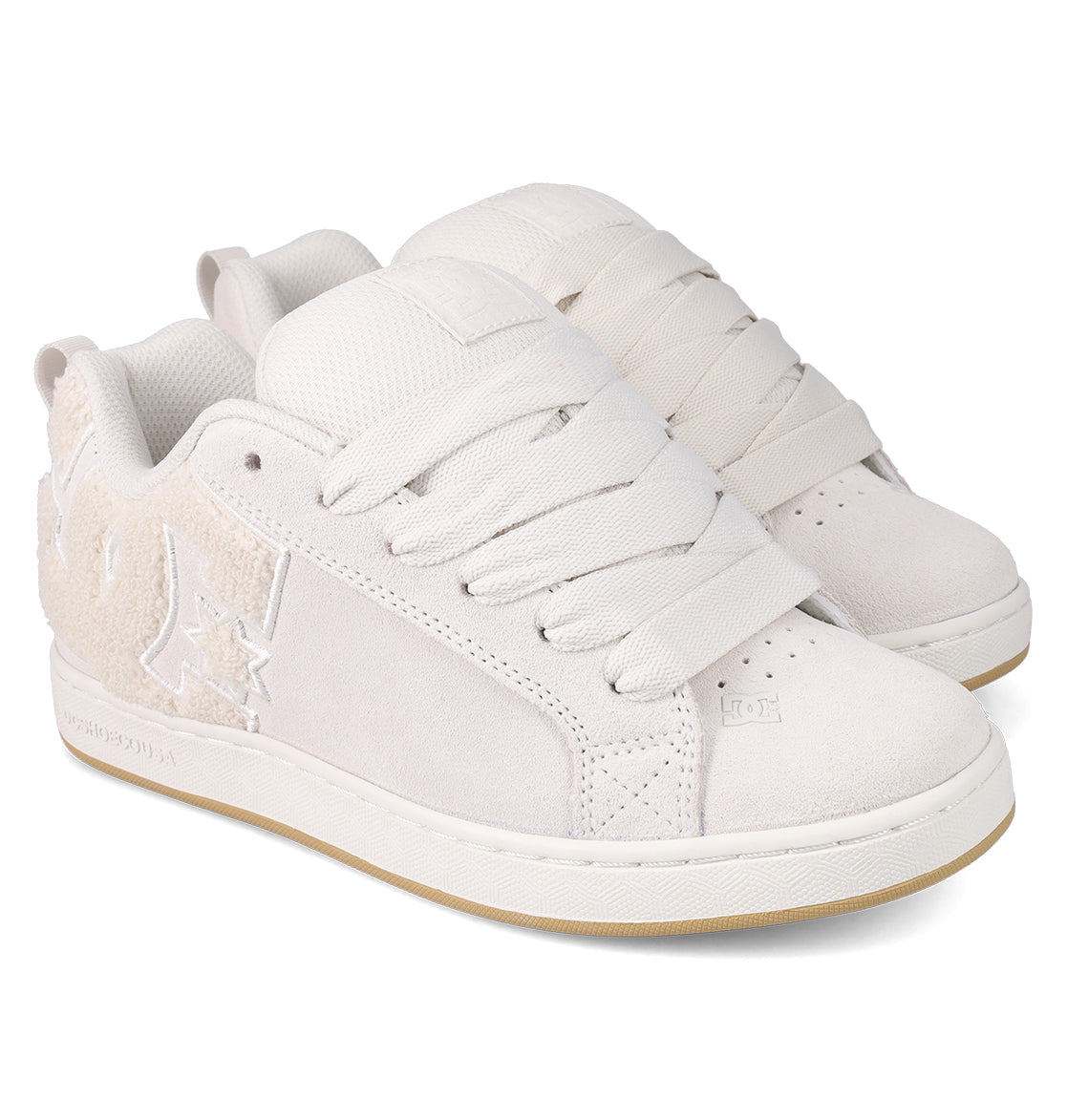 The Women's Court Graffik SD Shoes by DC Shoes feature an off-white suede upper, thick laces, textured side panels, a puffy silhouette, a light tan rubber sole, and modern stitched branding for casual style.