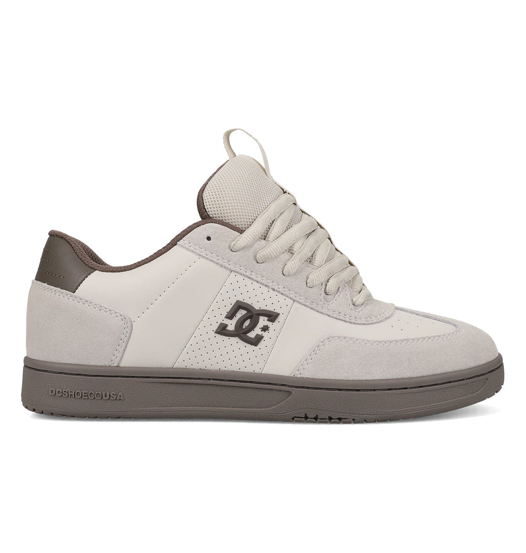 The DC Shoes Men’s Astrix Shoes feature a beige and gray colorway with a combination of leather and suede on the upper, a signature DC logo on the side, laces, and a durable rubber sole. Engineered for optimal board control, these skate shoes are shown in a side view against a white background.