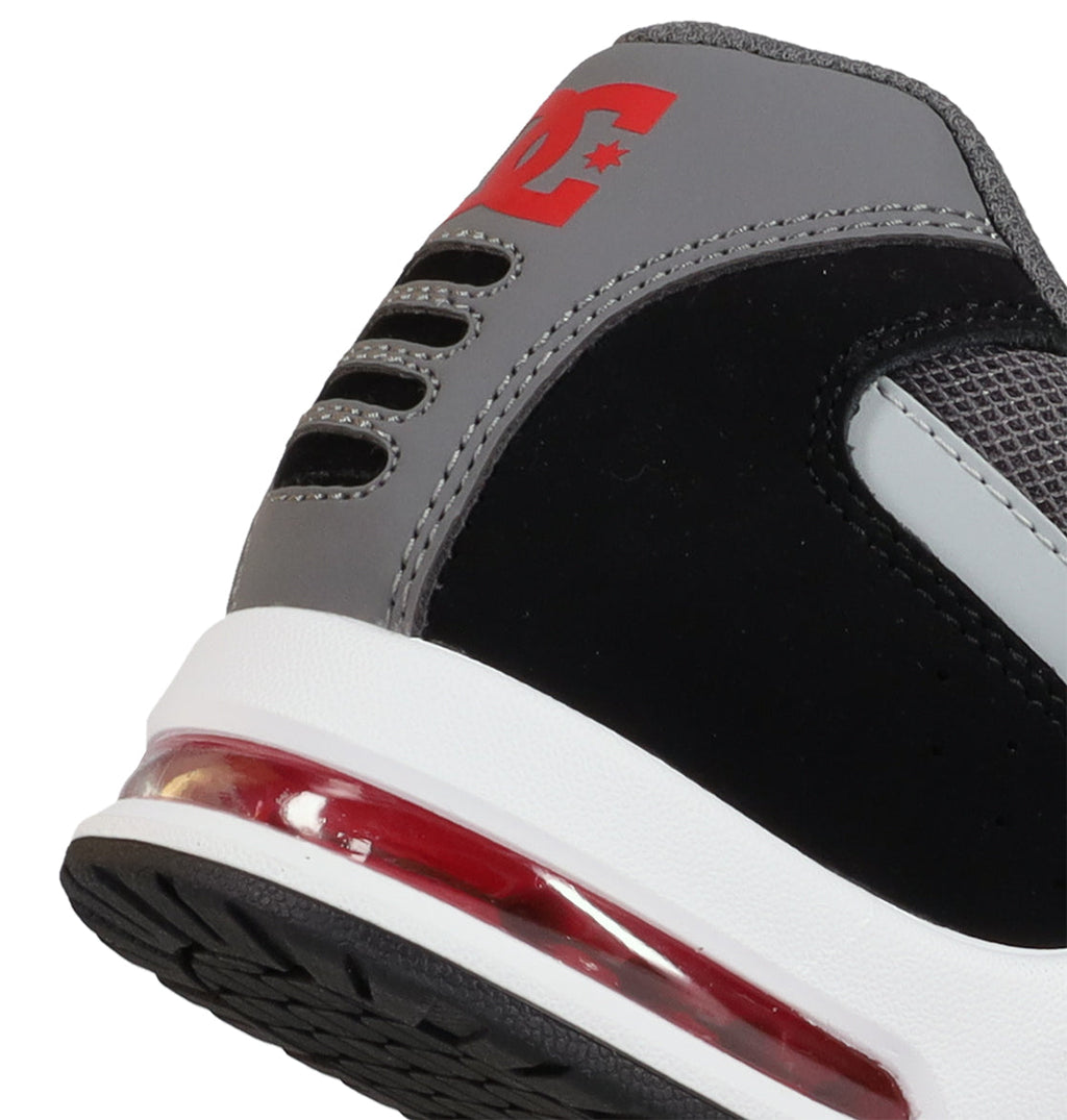 A close-up of the heel of the Men’s AT-2 Shoes by DC Shoes features a striking red air cushion, gray and black paneling, mesh details enhanced by the AEROTECH ventilation system, and a bold red DC Shoes logo near the ankle.