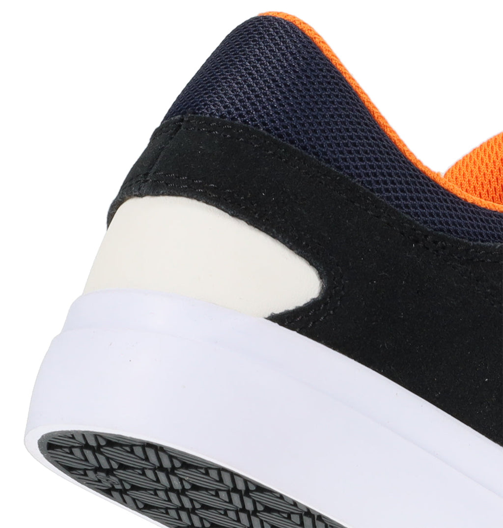 Close-up of the heel of the Men’s Onyx Skate Shoes by DC Shoes, featuring a black upper, white sole, orange lining, and a textured black-and-white bottom—an everyday go-to with a minimal silhouette.