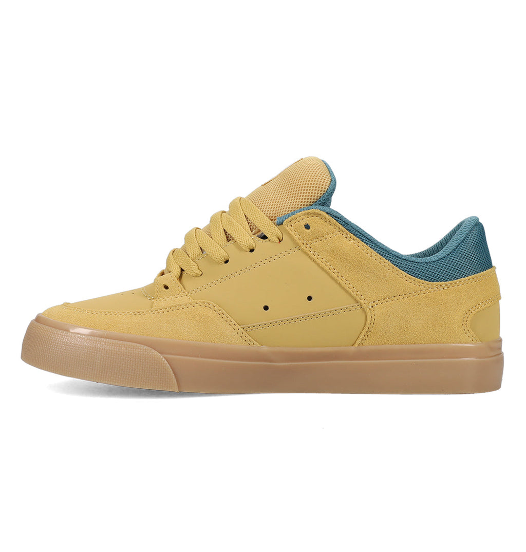 A left-side profile view of the DC Shoes Men’s Onyx Skate Shoes is shown against a white background, featuring a minimal silhouette in tan and mustard yellow with matching tan laces, a gum sole, and teal inner lining.