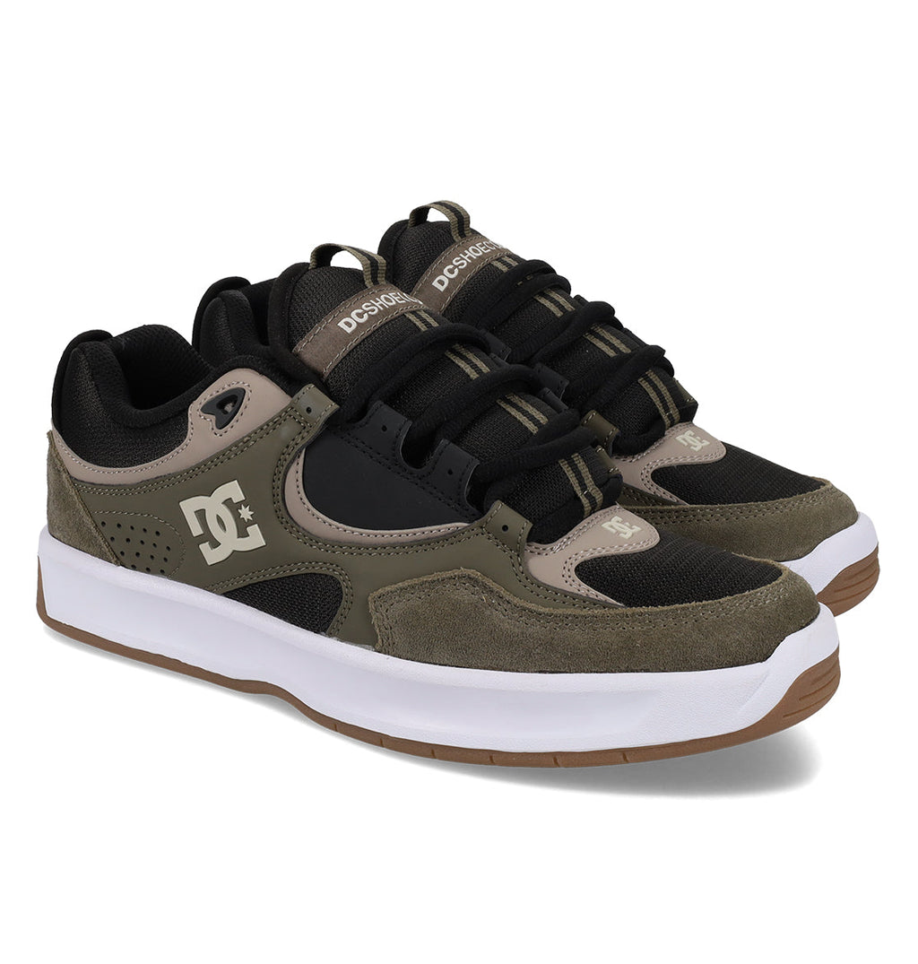 A pair of DC Shoes Men’s Kalynx Zero Shoes in green, brown, and black, featuring white midsoles, gum rubber outsoles, and the iconic DC logo on the side and tongue.