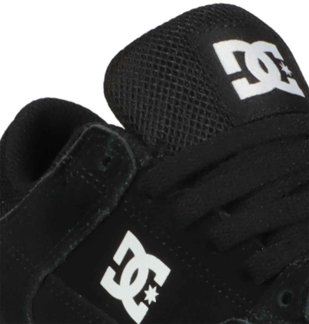 Close-up of the Kids’ Onyx Shoes in black, showcasing the white DC Shoes logo on the tongue and side, complemented by black laces and a mesh-textured upper. This minimal silhouette from DC Shoes offers an ideal everyday option for kids seeking style and comfort in a classic vulcanized design.