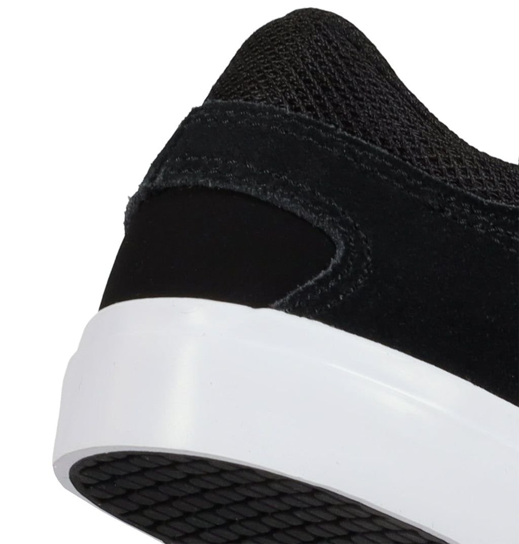 Close-up of the back heel of the Kids’ Onyx Shoes by DC Shoes, showcasing a minimal black sneaker design with a white sole and textured black outsole—making it an everyday go-to—set against a white background.