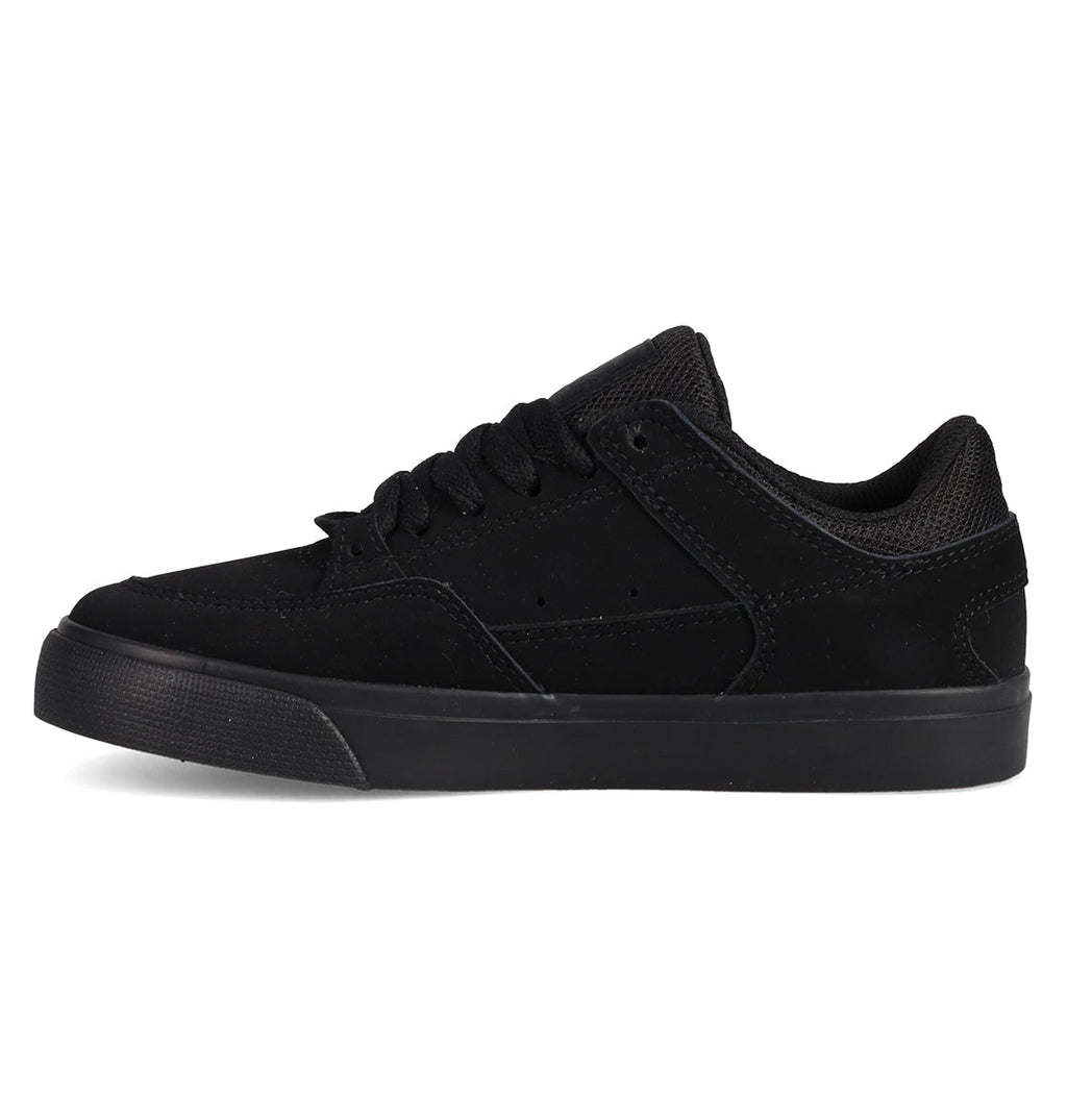 The Kids' Onyx Shoes by DC Shoes are black low-tops with a suede and mesh upper, black laces, and a black rubber sole. Shown in side view against a white background, they feature a minimal silhouette perfect for everyday wear.