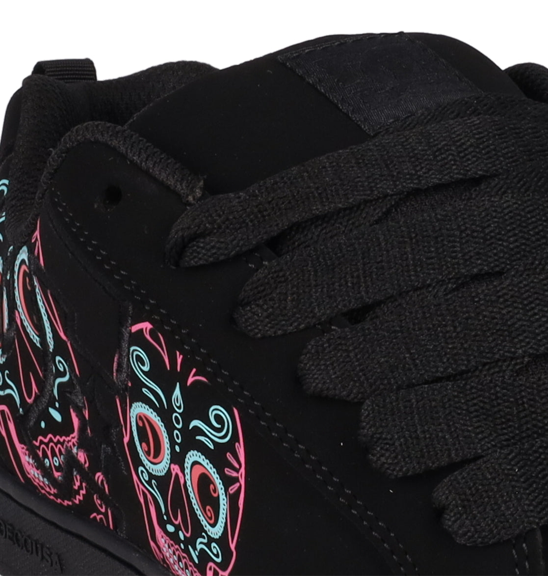 Close-up of the DC Shoes Women’s Court Graffik Day Of The Dead sneaker, showcasing thick black laces and a vibrant pink and light blue sugar skull design on the side, inspired by Día de los Muertos.